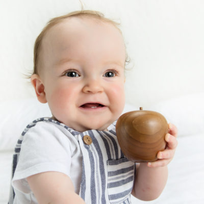 Baby holding wooden apple