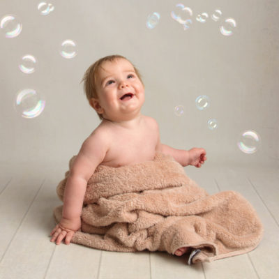 Baby wrapped in towel with bubbles