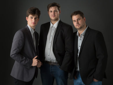 Three male siblings in dark suits