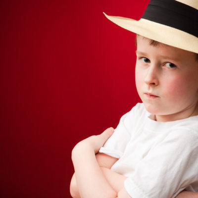 Young boy wearing a panama hat and serious expression