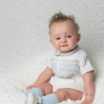 Smiling baby wearing smocked clothing
