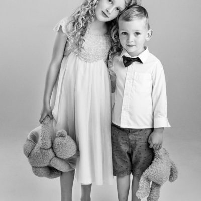 Young siblings hugging holding teddies